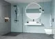 Badezimmer mit Dusche, Wandregal und Waschbecken von Ideal Standard. Helle Farben und moderne Beleuchtung schaffen eine zeitgemäße Atmosphäre.